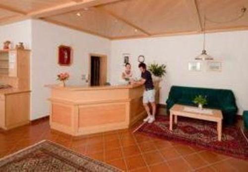 a man standing at a counter in a living room at Pension Steingarten in Appiano sulla Strada del Vino