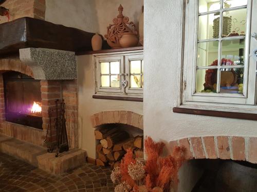 a living room with a brick fireplace and a window at Bed And Breakfast Olimpia in San Salvatore Monferrato