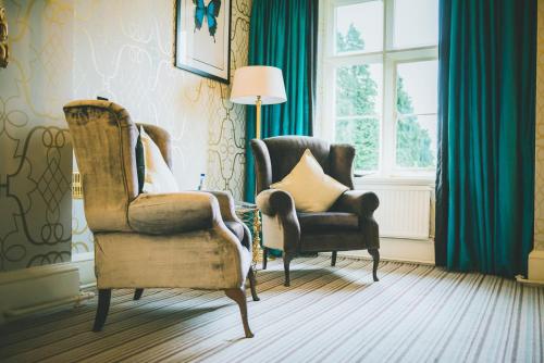 a living room with two chairs and a window at The Coed-Y-Mwstwr Hotel in Bridgend