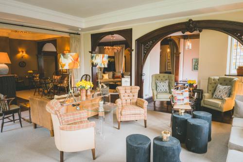 a living room with a table and chairs at The Coed-Y-Mwstwr Hotel in Bridgend