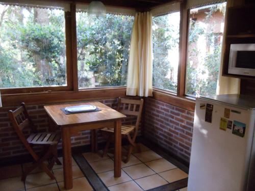 a small kitchen with a table and a refrigerator at Cabañas El Ocio in Mar de las Pampas