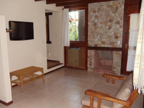 a living room with a couch and a fireplace at Cabañas El Ocio in Mar de las Pampas