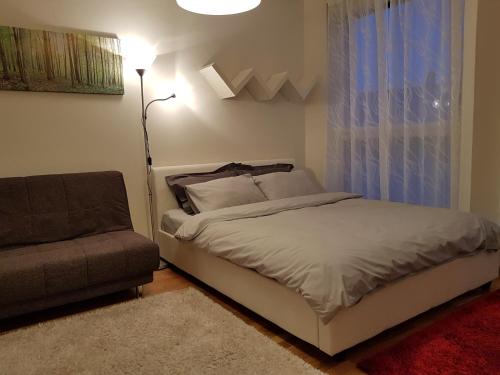a bedroom with a bed and a couch and a window at Rotermanni Guest Apartments in Tallinn