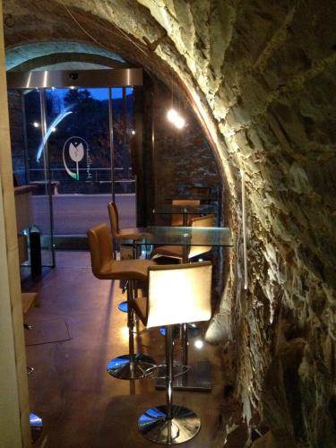 a restaurant with a stone wall and tables and a lamp at Morelliana4Rooms in Scansano