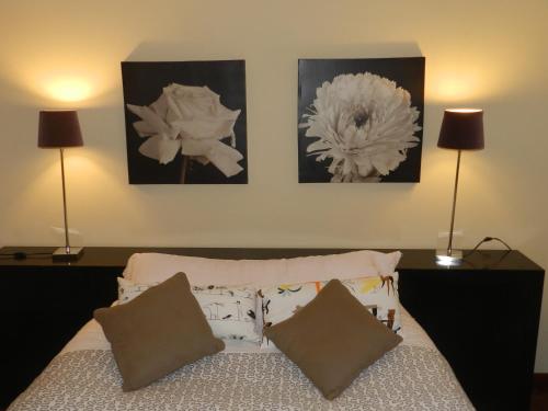 パレーデス・デ・コウラにあるAlojamento do Minhoのベッドの上に3枚の写真が飾られたベッドルーム1室