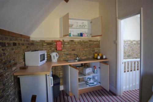 a small kitchen with a counter and a microwave at St Peters Bed and Breakfast in Sandwich