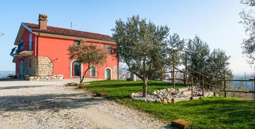 uma casa vermelha com uma cerca em frente em Agriturismo San Michele em Paternopoli