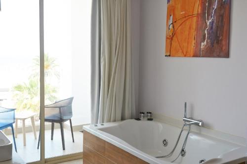 a bathroom with a tub and a table and a chair at Hotel Boutique Sabbia Valencia in Valencia