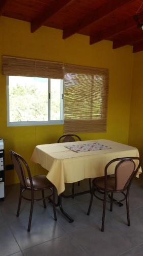una mesa y sillas en una habitación con una pared amarilla en Samana Holiday, en Carpintería