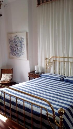 a bedroom with a bed with a blue and white striped blanket at Il Capriolo in Celle Ligure