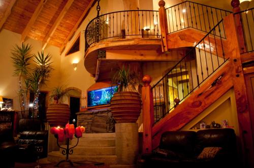 a living room with a spiral staircase in a house at Tree House Lodge Bed & Breakfast in Cheviot