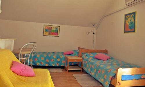 a room with two beds and a couch at Studio Silvana & Room Renata in Lumbarda