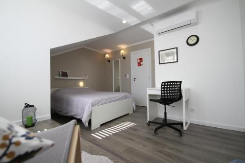 um quarto com uma cama, uma secretária e uma cadeira em Alfama Right Point em Lisboa