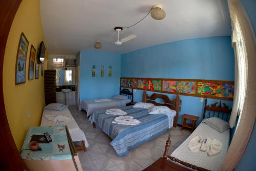 a bedroom with two beds and a mirror at Pousada Recanto de Minas in Porto Seguro