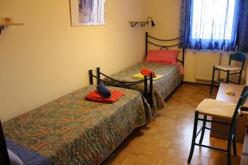 Appartamento Galileo في بادوفا: غرفة نوم بسريرين وطاولة وكرسي