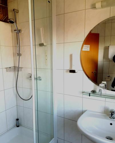 a bathroom with a shower and a sink and a mirror at Legend Hotel in Biebesheim