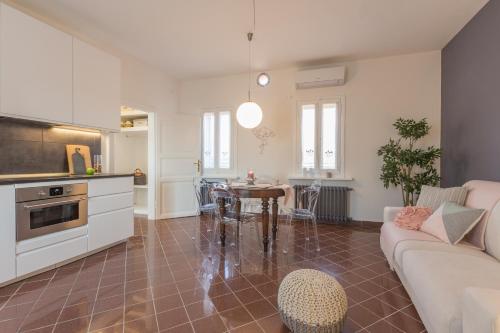 a kitchen and living room with a couch and a table at Palazzo Spada - Attico con terrazza vista fiume in centro in Codigoro