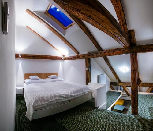 プラハにあるApartments At The Blue Ducklingの木製の天井の客室で、ベッドルーム1室(ベッド1台付)