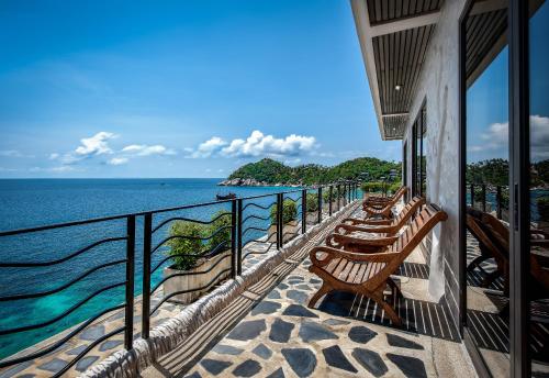 a row of benches on a balcony overlooking the ocean at Jamahkiri Dive Resort & Spa in Koh Tao
