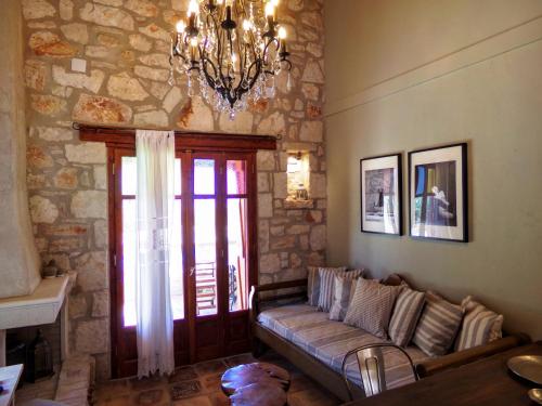 a living room with a couch and a chandelier at Alegria Villas Complex in Vasilikos