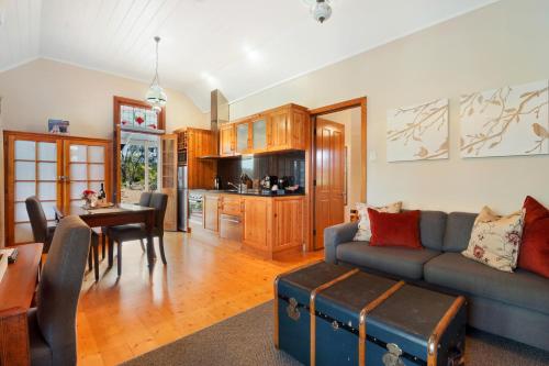 a living room with a blue couch and a table at Stonewell Cottages and Vineyards in Tanunda