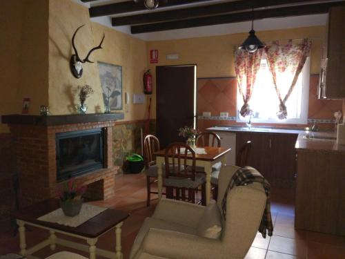 sala de estar con chimenea, mesa y sillas en Casa Rural Sierra De Coripe, en Coripe