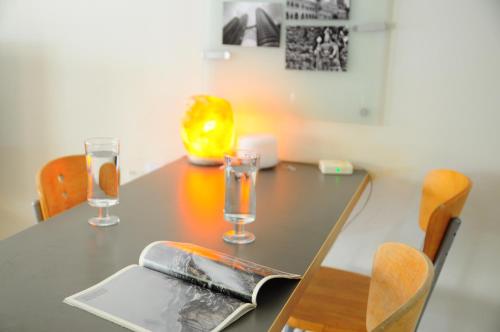 a dining room table with two glasses on it at GRAYHAUS Guest House in Petaling Jaya