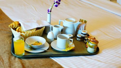 a tray with breakfast foods and drinks on a bed at Al Muhaidib Hotel in Riyadh