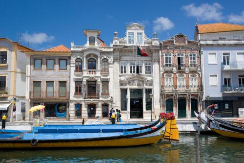 a boat in the water in front of buildings at Hotel Aveiro Center in Aveiro