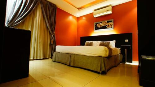 Un dormitorio con una pared de color naranja y una cama. en Sama Al Qasr Al Muhammadiah, en Riad