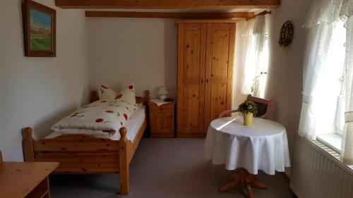 a bedroom with a bed and a table and a window at Jägerheim Löbsal in Löbsal
