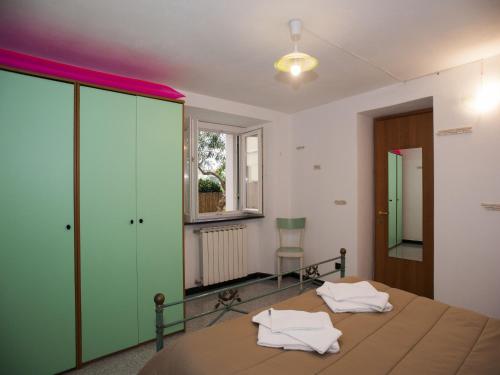 a bedroom with a bed with green cabinets and a window at Il Leudo in Levanto