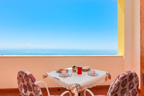 une table et deux chaises avec une table et une fenêtre dans l'établissement Villa Matilde Amalfi, à Amalfi