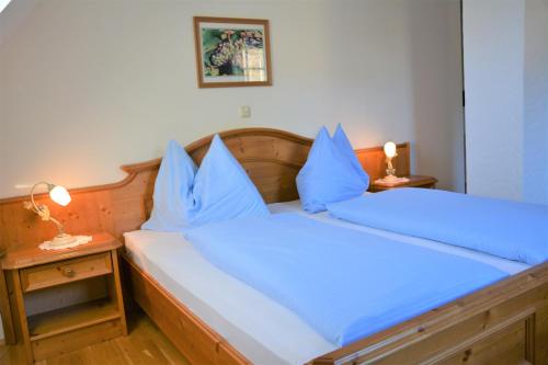 a bedroom with a bed with blue pillows on it at Weingut Seiner vlg. Kraxner in Greisdorf