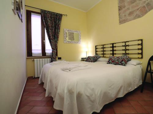 - une chambre avec 2 lits avec des draps blancs et une fenêtre dans l'établissement Residenza Raffaello, à Foligno