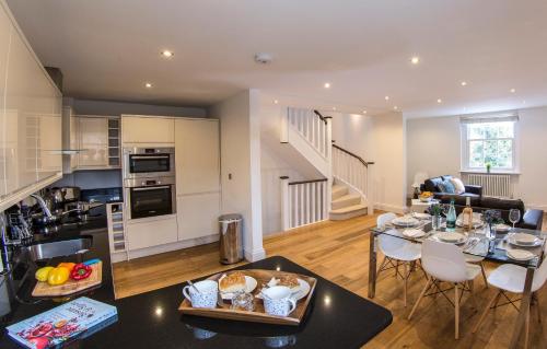 a kitchen and living room with a table and chairs at Finchley Central Luxury 3 bed triplex loft style apartment in Hendon