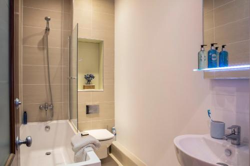 y baño con ducha, lavabo y aseo. en Finchley Central Luxury 3 bed triplex loft style apartment, en Hendon