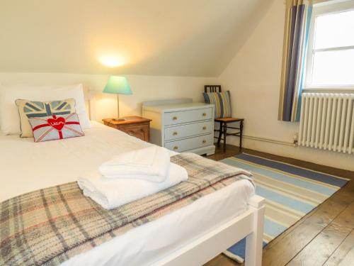una camera con letto, cassettiera e finestra di Thimble Cottage ad Aldeburgh