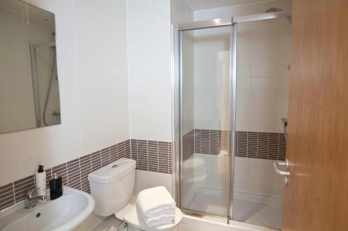 a bathroom with a shower and a toilet and a sink at Watford Centre - Luxury Penthouse in Watford