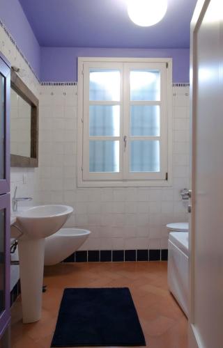 a bathroom with a sink and a toilet and a window at Il Borghetto in Cavriago