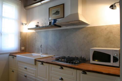 a kitchen with a microwave and a stove and a sink at Il Borghetto in Cavriago
