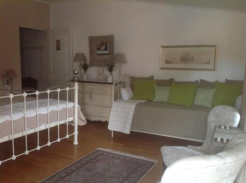 ein Wohnzimmer mit einem Bett und einem Kinderbett in der Unterkunft Le petit Figuier in La Roque-dʼAnthéron