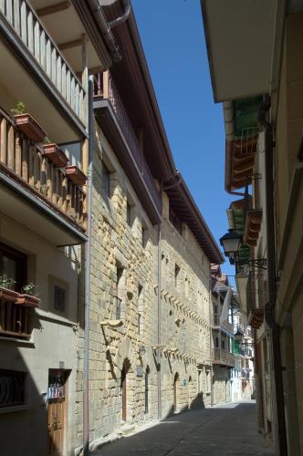 an alley with a stone wall in a street at Saiaz Getaria Hotela in Getaria