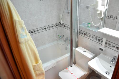 a bathroom with a shower and a toilet and a sink at Hotel Dva Bisera in Ohrid