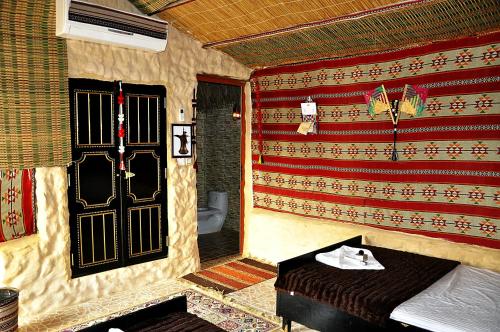 a room with a bathroom with a door and a table at Al Reem Desert Camp in Jalan Bani Buhassan