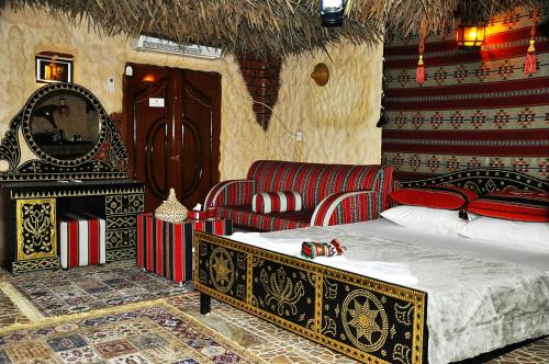 a bedroom with a bed and a couch and a fireplace at Al Reem Desert Camp in Jalan Bani Buhassan