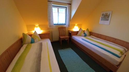 2 letti in una piccola camera con pareti gialle di Haus Herrensee Litschau a Litschau