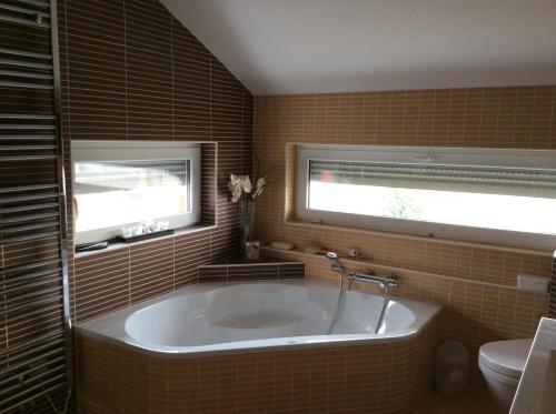 eine Badewanne im Bad mit Fenster in der Unterkunft Lakeside Villa in Frauenkirchen