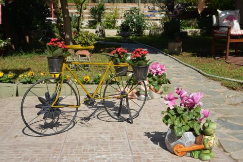 a yellow bike parked next to flowers in a garden at House with Big Garden in Korinthos