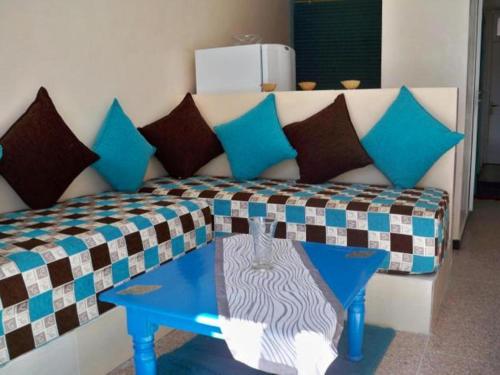 a couch with pillows and a table in a room at Residence Tafat in Agadir